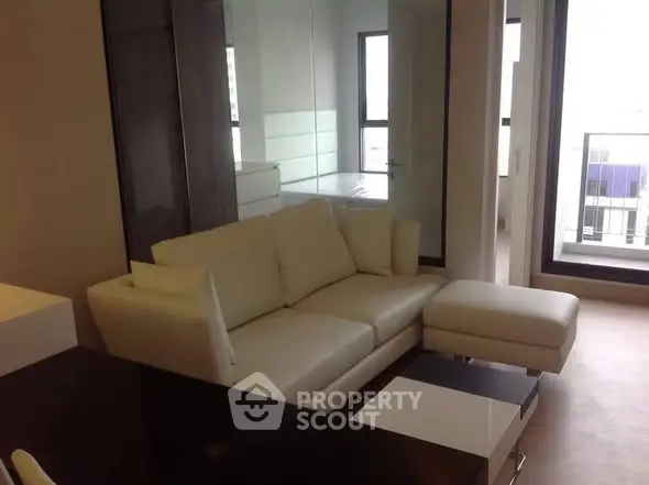 Modern living room with white sofa and large windows offering natural light.