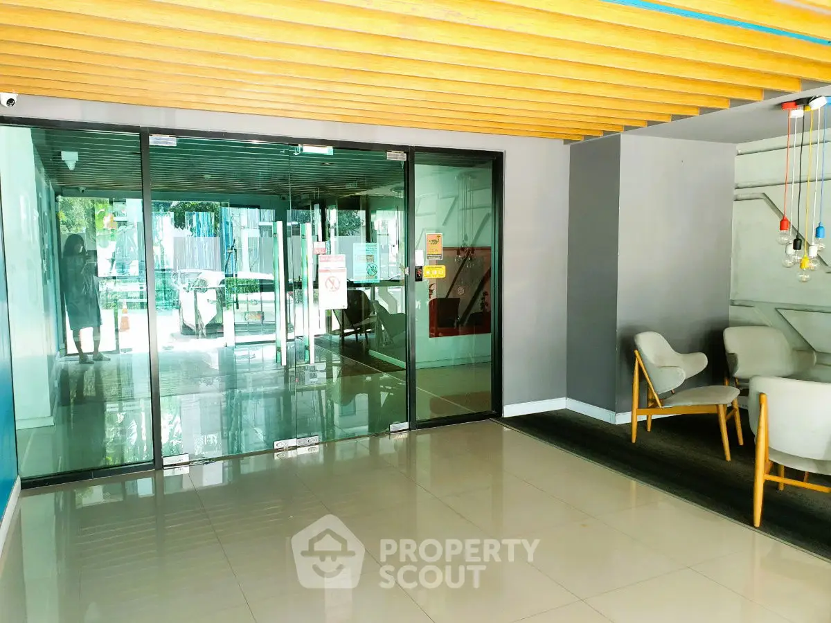 Modern building entrance with glass doors and stylish seating area