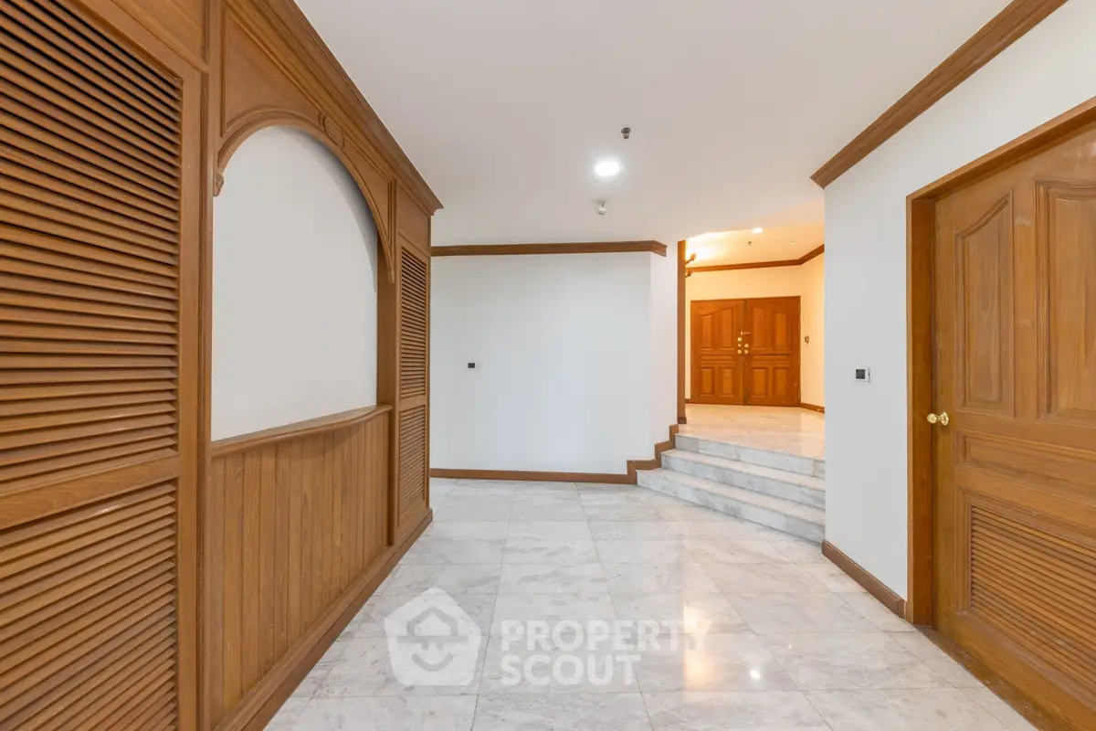 Elegant building entrance with marble flooring and wooden accents