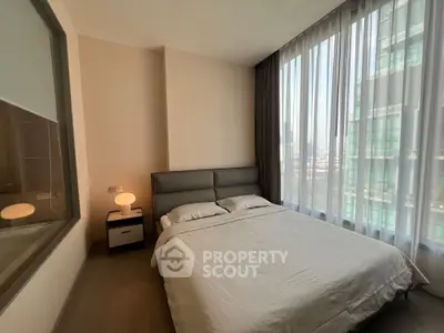 Modern bedroom with large windows and city view, featuring a cozy bed and stylish decor.