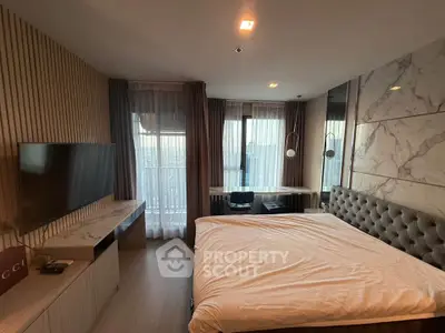 Luxurious bedroom with modern decor and large windows offering natural light.