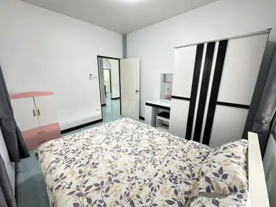 Cozy bedroom with modern furniture and floral bedding in a bright, inviting space.