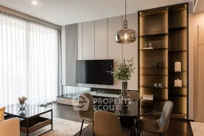 Elegant modern living room with stylish furniture and large TV, featuring floor-to-ceiling windows and chic decor.
