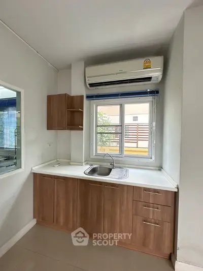 Modern kitchen with sleek cabinetry and air conditioning unit