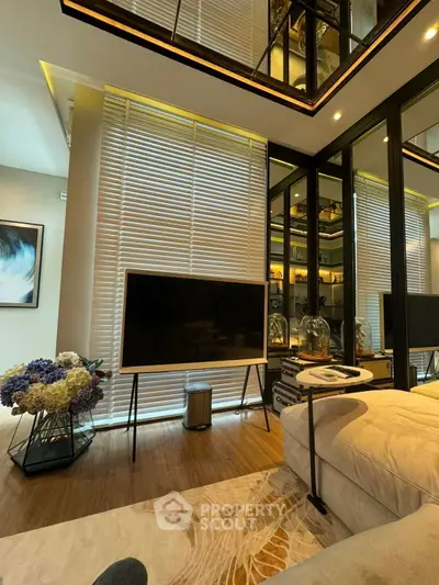 Luxurious modern living room with stylish decor and large TV, perfect for relaxation and entertainment.