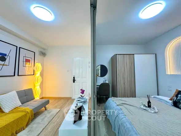 Modern apartment interior with stylish living room and cozy bedroom, featuring contemporary decor and ample lighting.