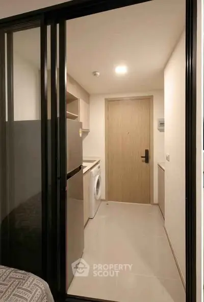 Modern apartment entrance with sleek kitchen and washing machine