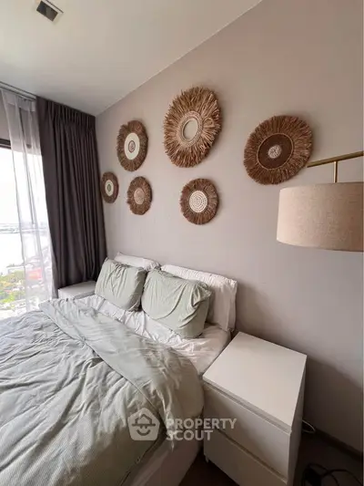Cozy bedroom with stylish decor and natural light, featuring a comfortable bed and elegant wall art.
