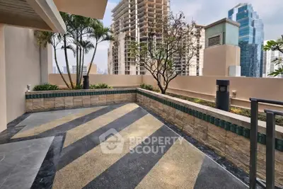 Spacious urban balcony with city skyline views and modern landscaping.