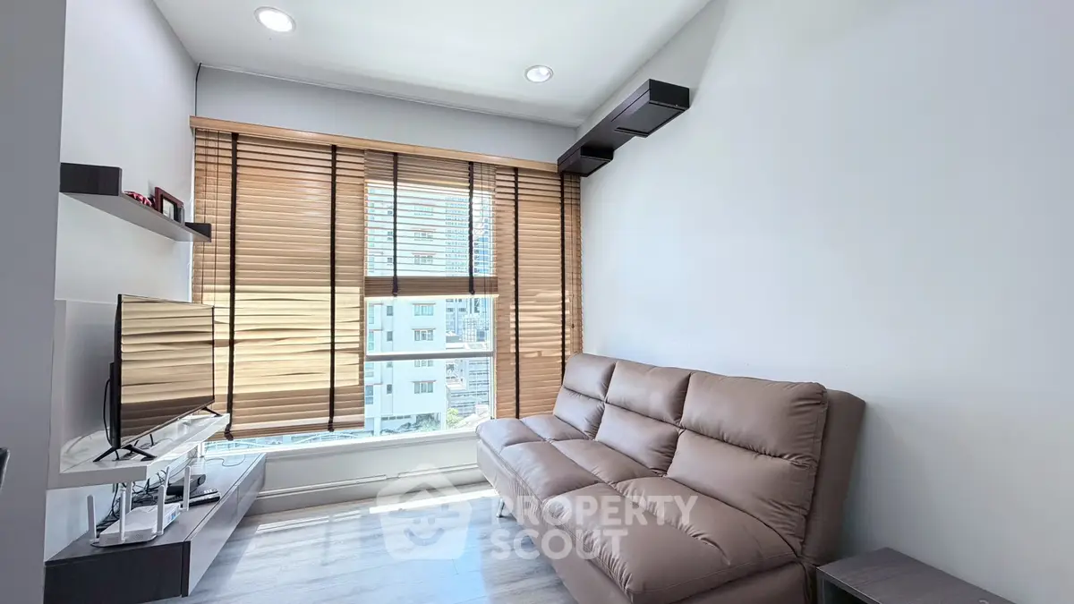 Modern living room with cozy sofa and large window offering natural light.