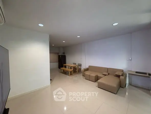 Spacious living room with modern furniture and dining area in open layout.