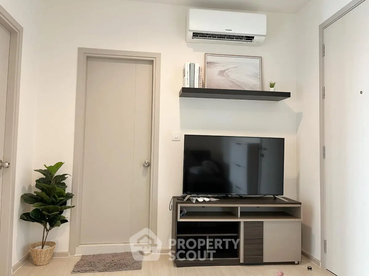 Modern living room with sleek TV stand, air conditioning, and minimalist decor.