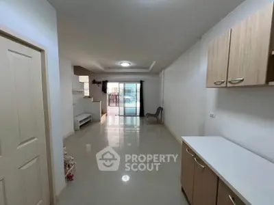 Spacious open-plan living area with modern cabinetry and large windows.