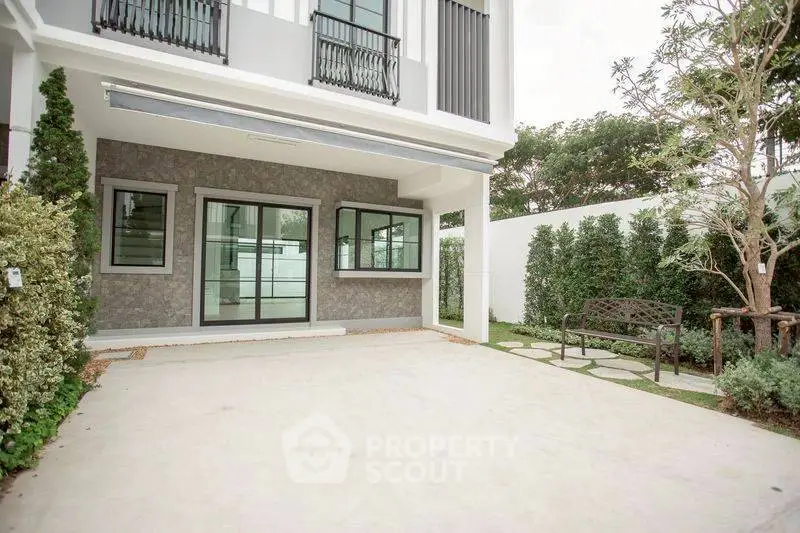 Modern townhouse exterior with spacious driveway and lush garden