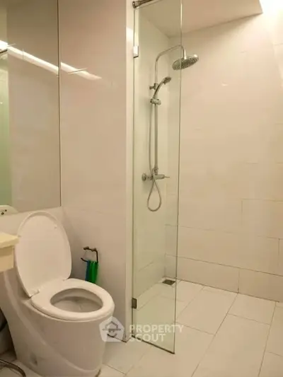 Modern bathroom with glass shower and sleek white tiles