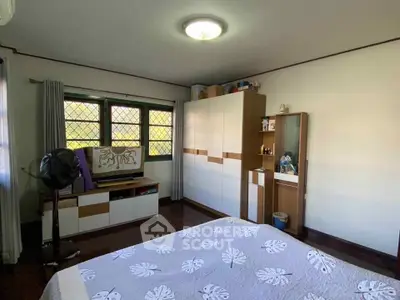 Spacious bedroom with modern furniture and ample natural light.