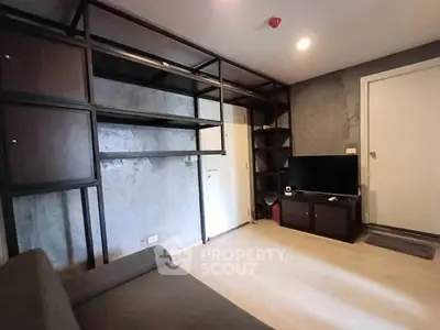 Modern living room with sleek shelving and TV unit, featuring minimalist design and neutral tones.