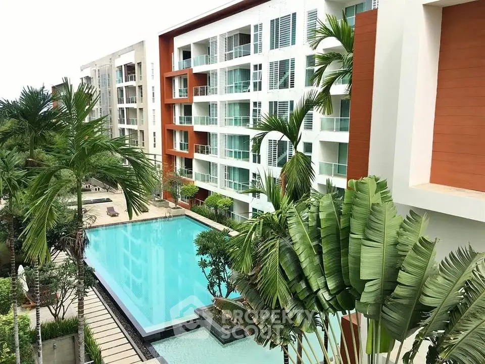 Luxurious apartment complex with a stunning pool and lush greenery, perfect for modern living.