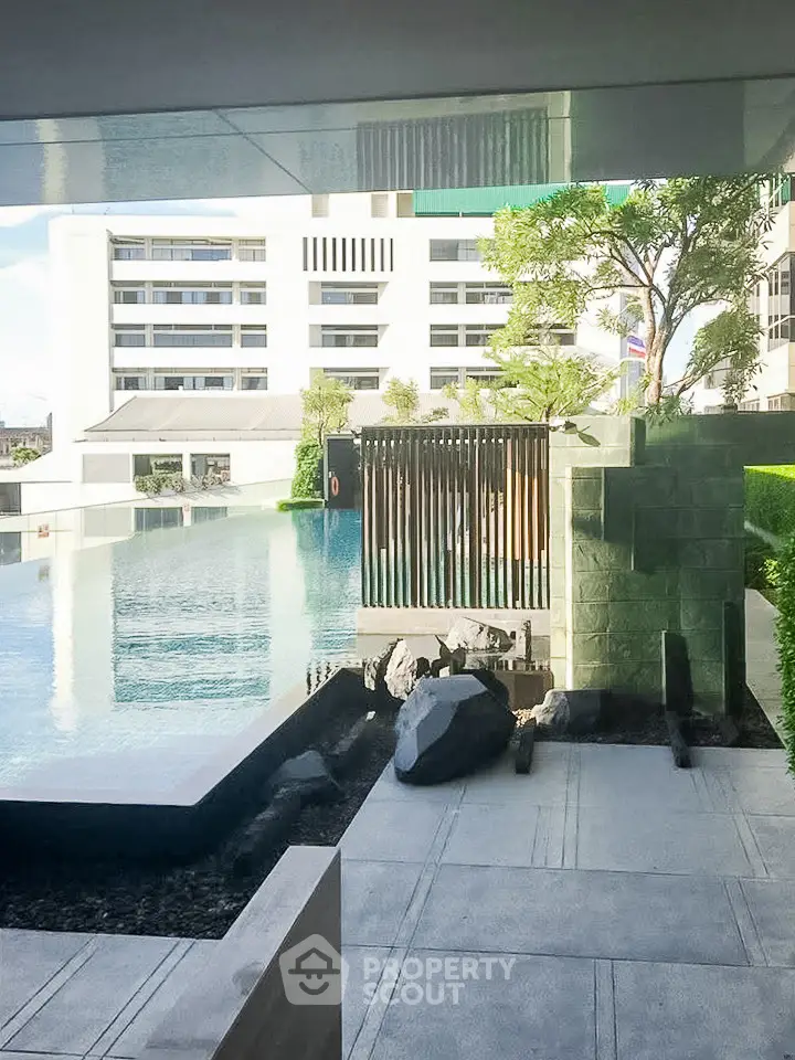 Luxurious apartment complex with stunning pool and modern architecture.