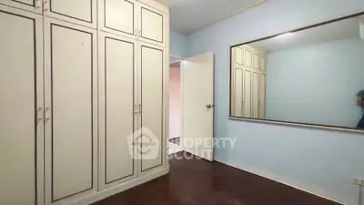 Spacious bedroom with large mirror and built-in wardrobe, perfect for modern living.