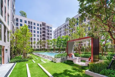 Luxurious residential complex with lush garden and inviting pool area, perfect for relaxation and leisure.