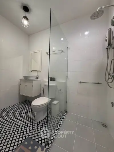 Modern bathroom with glass shower, stylish tiles, and contemporary fixtures.