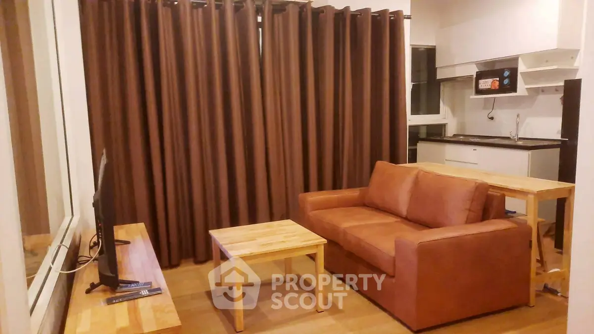 Cozy living room with brown sofa, wooden tables, and large window with curtains in modern apartment.