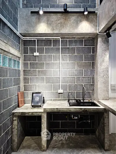 Industrial-style kitchen with concrete countertops and exposed brick walls
