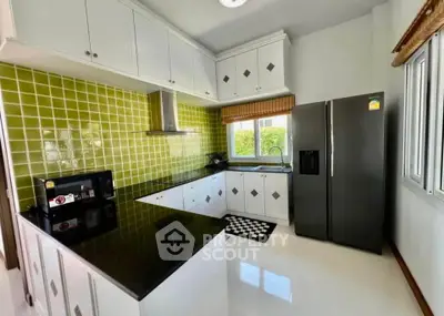 Modern kitchen with green tile backsplash and sleek black countertops