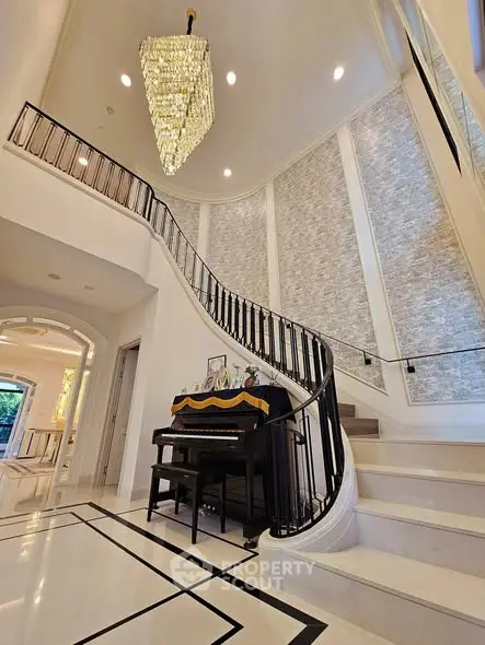 Luxurious foyer with grand staircase and elegant chandelier