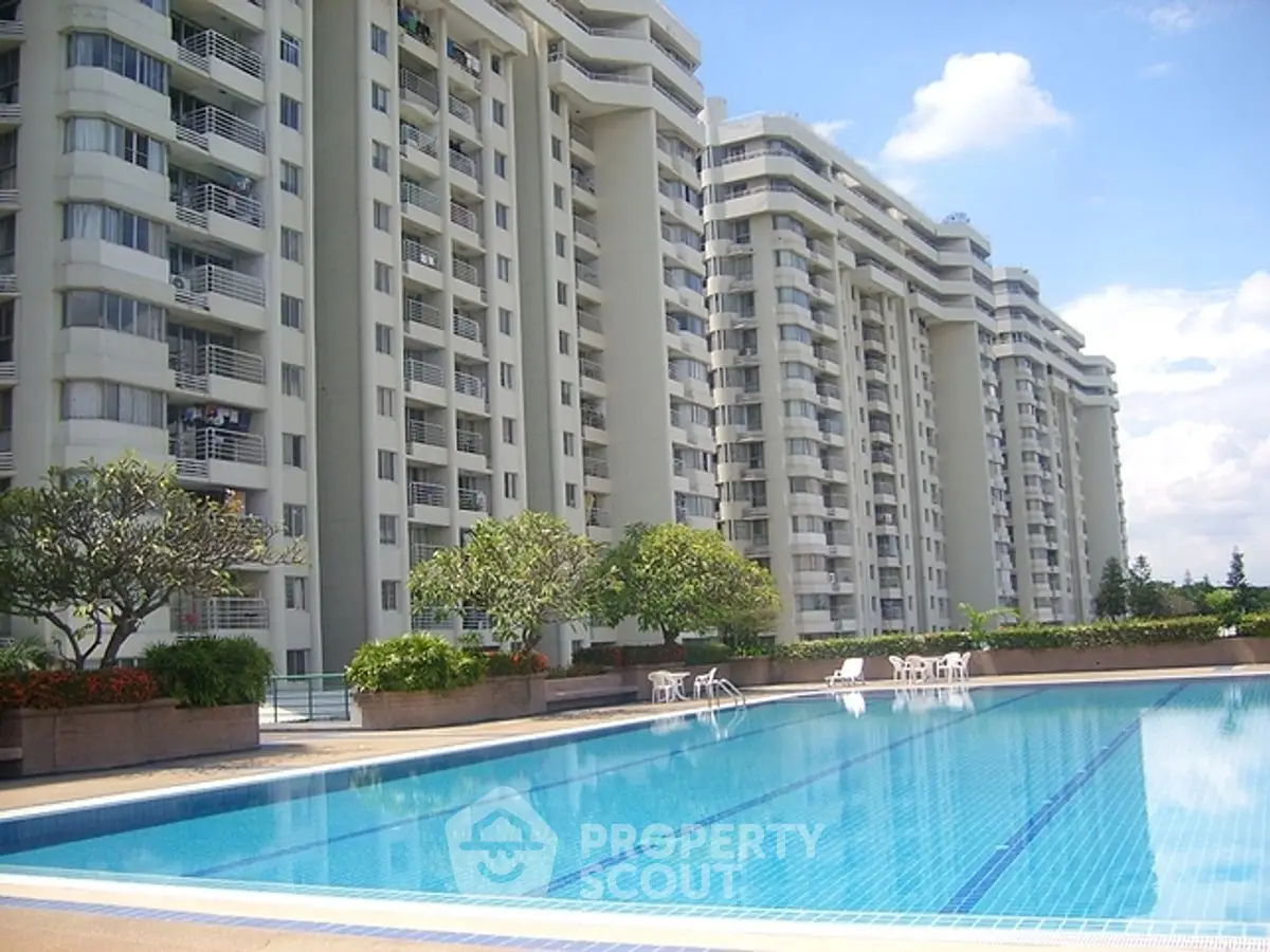 Luxurious apartment complex with a stunning outdoor pool and modern architecture.