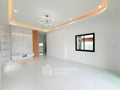 Spacious modern living room with elegant lighting and marble accent wall