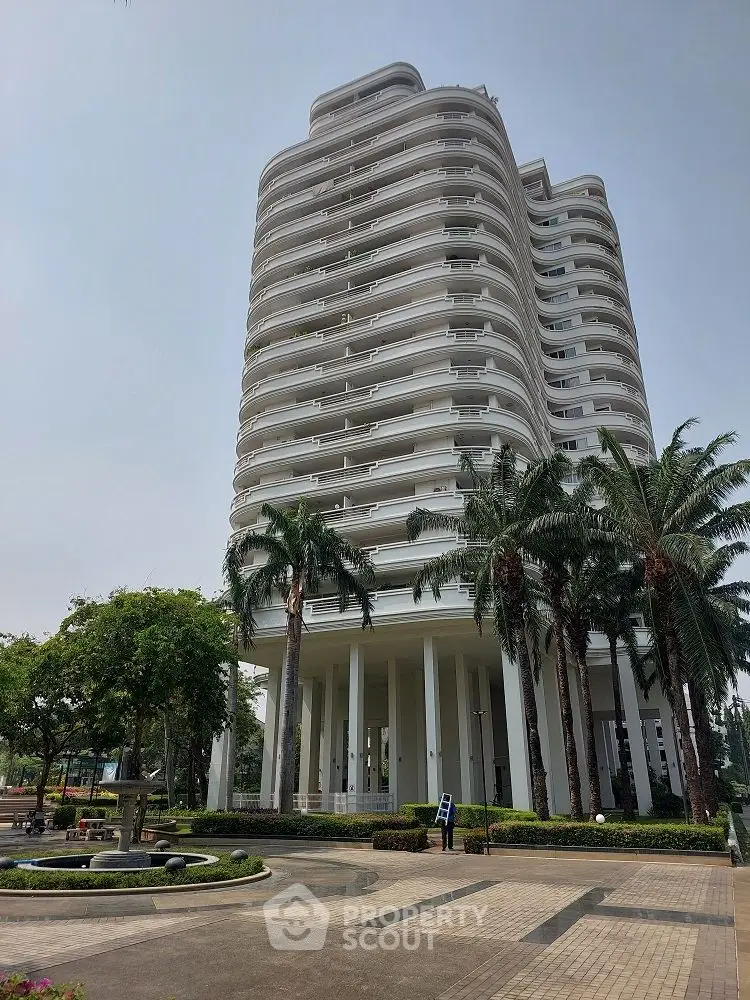 Stunning modern high-rise building with lush landscaping and palm trees, perfect for luxury living.