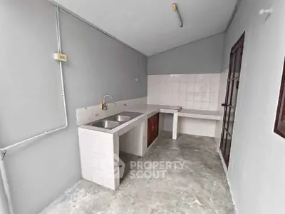 Spacious kitchen with dual sink and tiled backsplash in modern home.