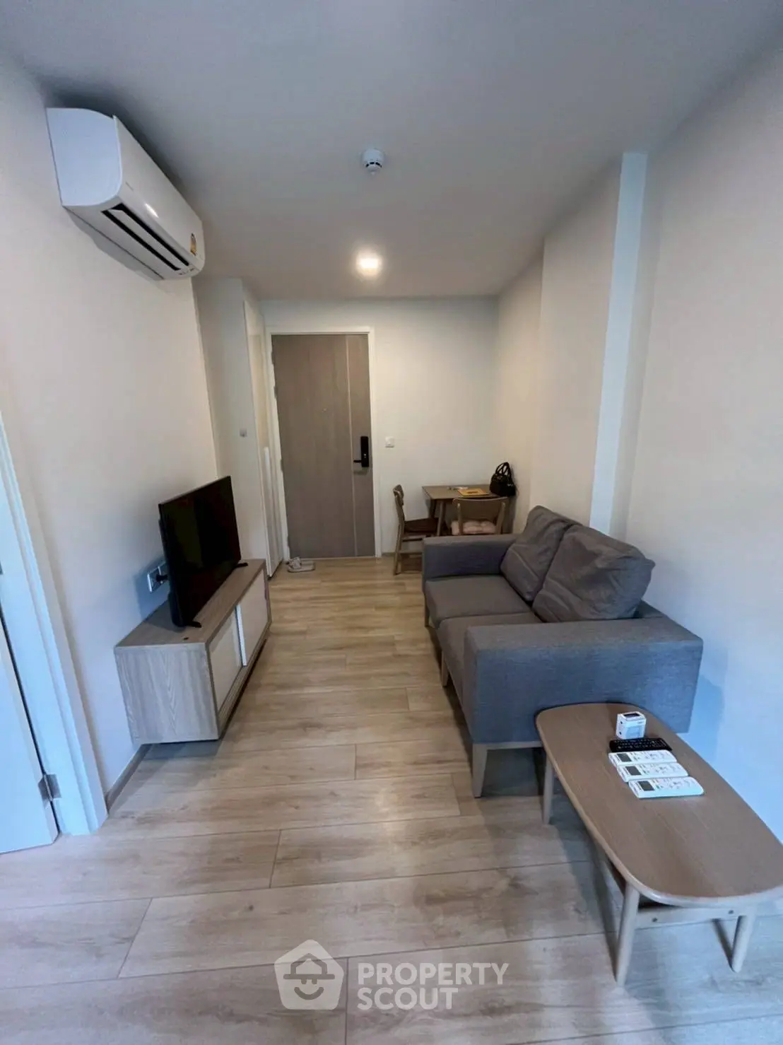 Modern living room with sleek furniture and wooden flooring in a cozy apartment.