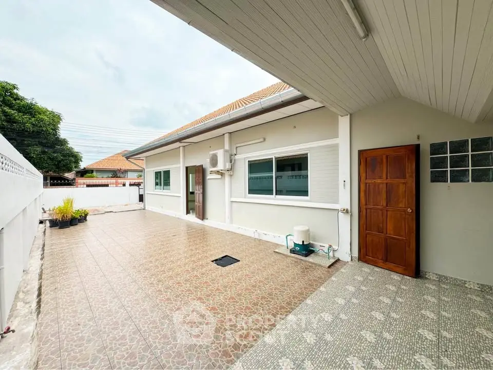 Spacious exterior view of a modern single-story home with tiled patio and air conditioning unit.