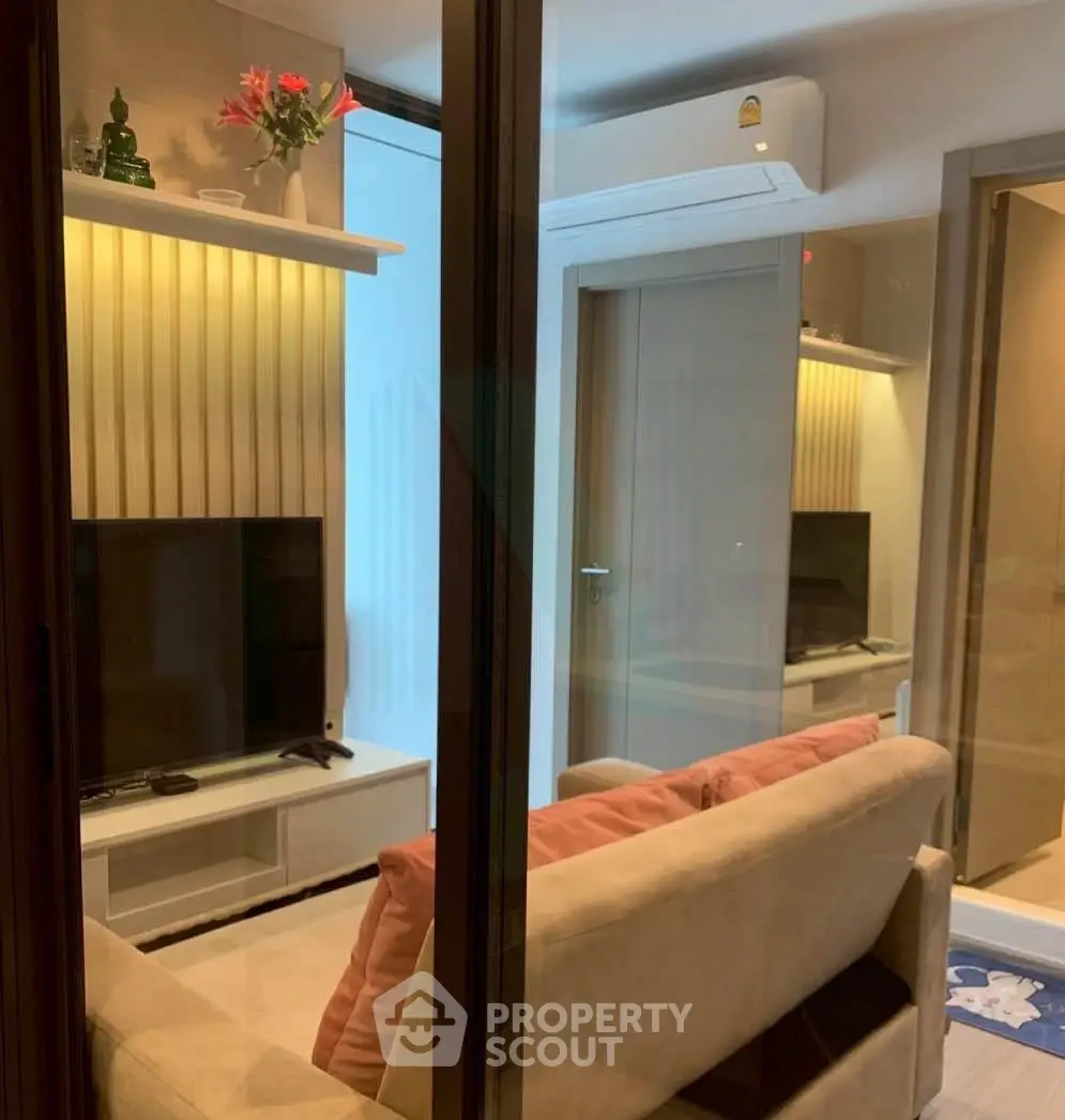 Modern living room with cozy sofa, wall-mounted TV, and stylish decor in a contemporary apartment.