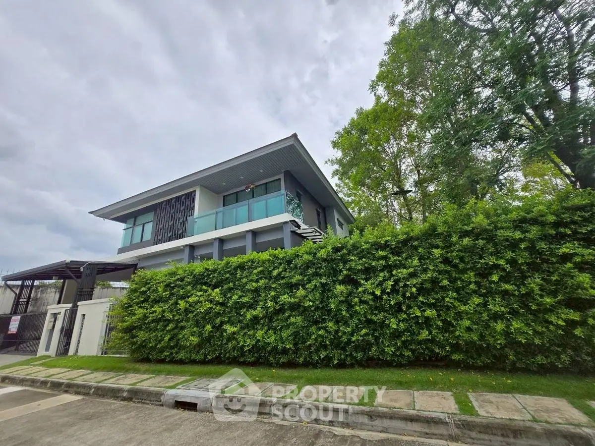 Modern two-story house with lush greenery and contemporary design