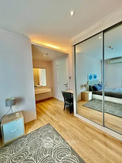 Modern bedroom with mirrored closet and stylish decor in a cozy apartment.