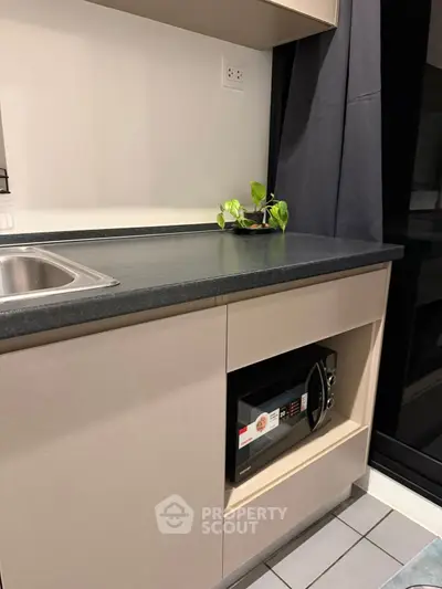 Modern kitchen with sleek countertop and built-in microwave, perfect for urban living.