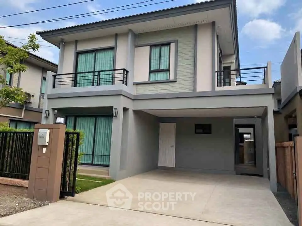 Modern two-story house with spacious driveway and balcony in a suburban neighborhood.