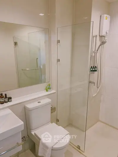 Modern bathroom with glass shower and sleek fixtures in a contemporary apartment.