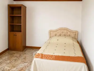 Cozy bedroom with single bed and wooden cabinet, perfect for minimalist living.
