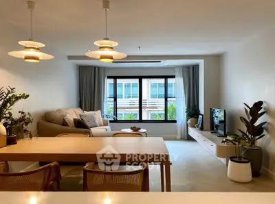 Spacious living room with modern decor and large window view