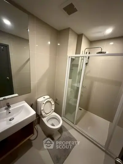 Modern bathroom with glass shower and sleek fixtures in a contemporary apartment.