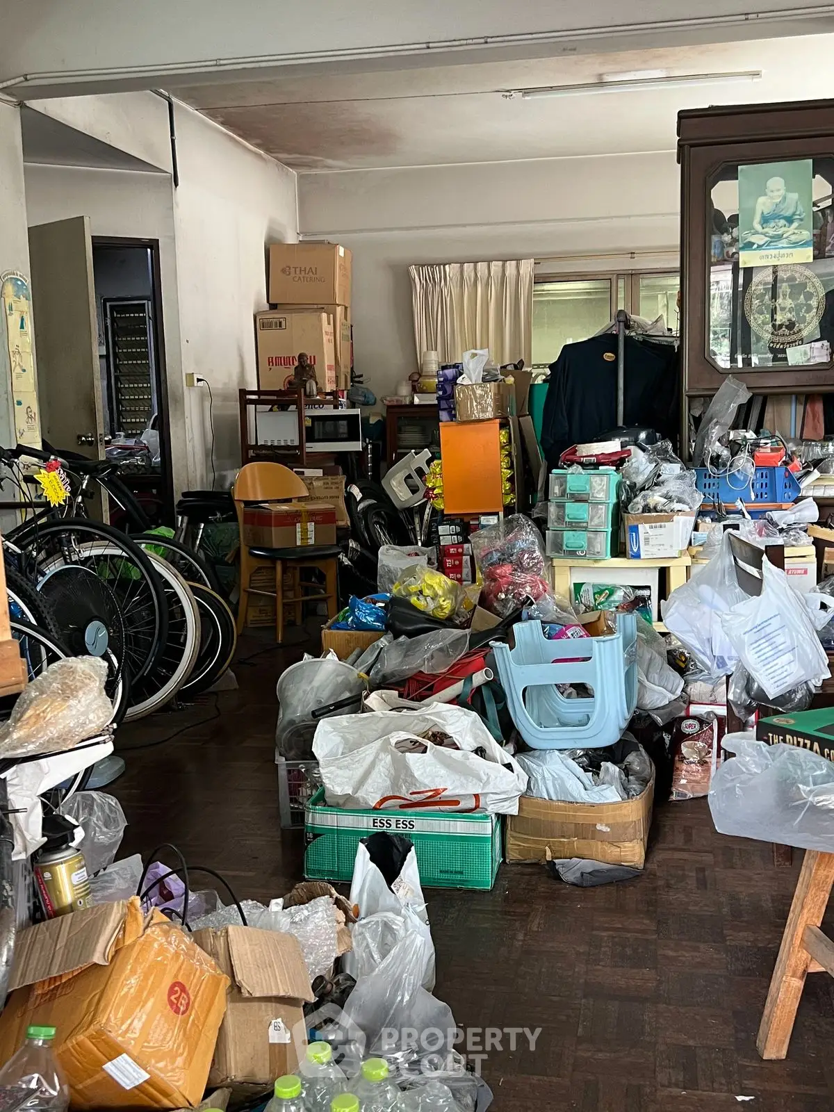 Cluttered storage room filled with boxes, bags, and miscellaneous items in a residential property.