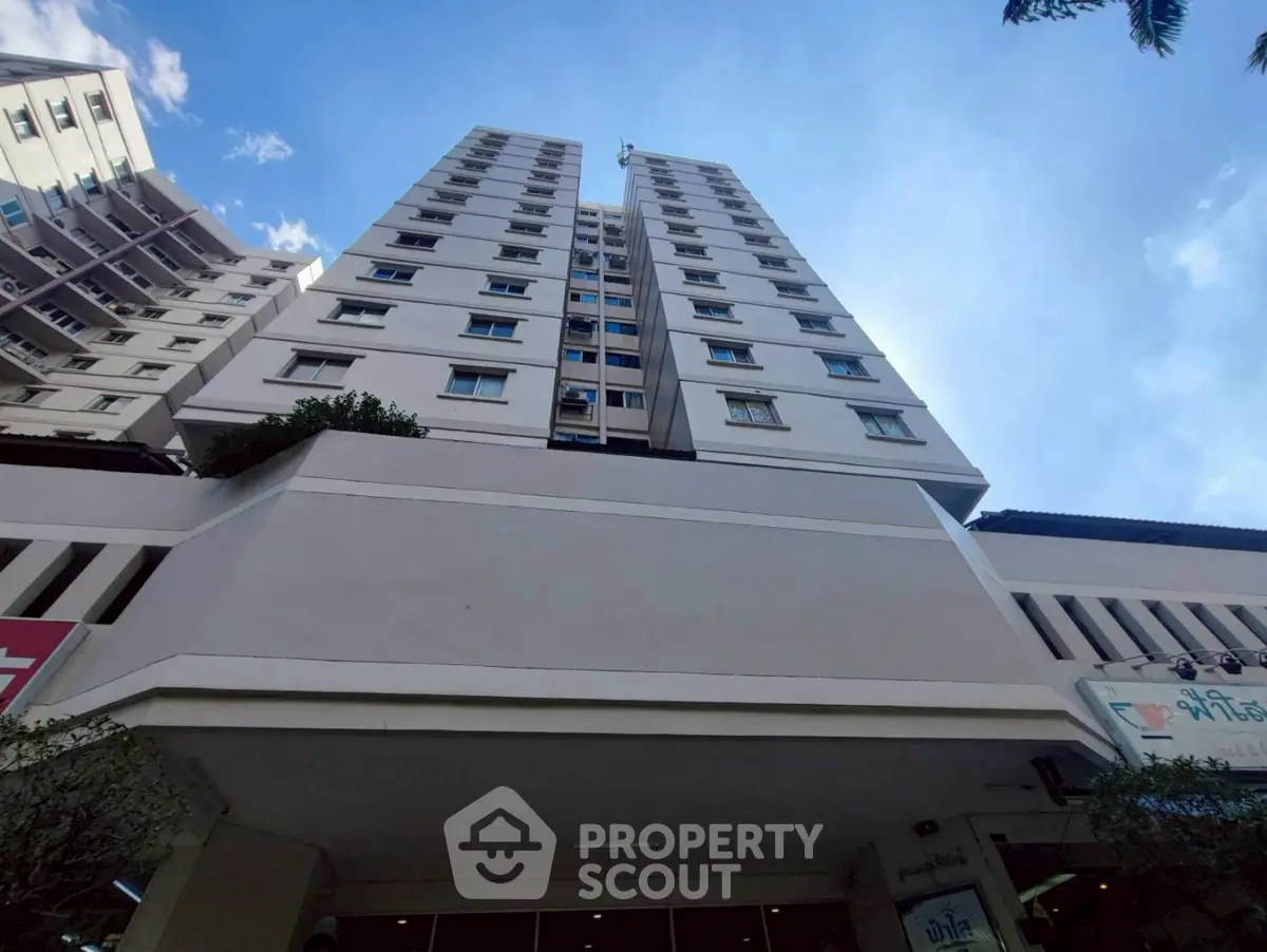 Modern high-rise building with clear blue sky backdrop, showcasing urban living.