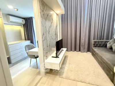 Modern living room with stylish decor and cozy seating area, featuring elegant curtains and a sleek TV setup.