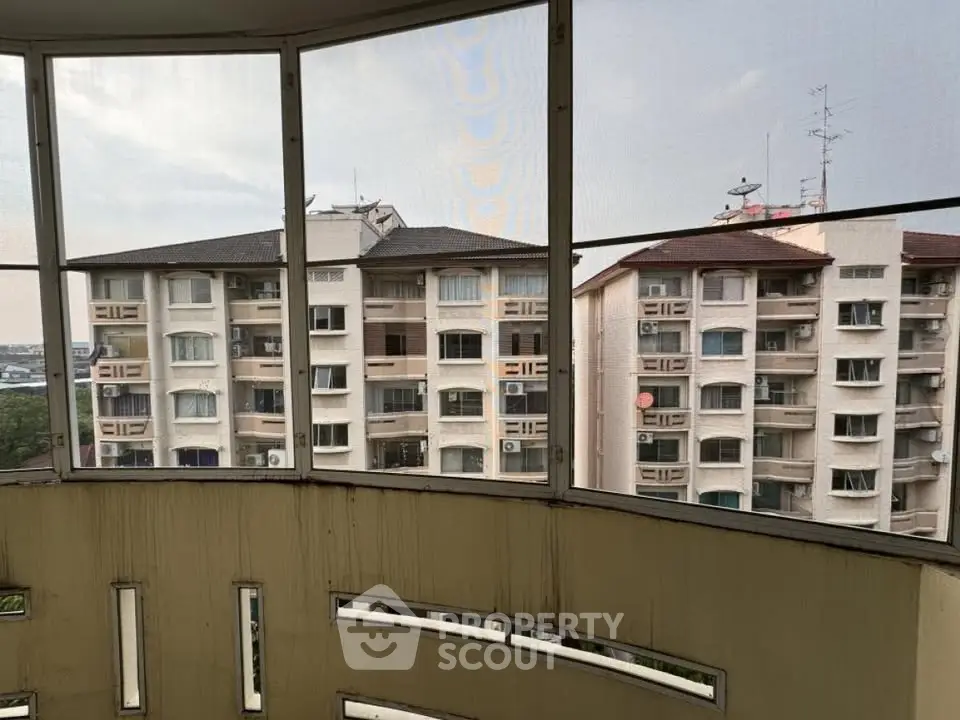 Panoramic view from a balcony showcasing nearby residential buildings with a clear sky.