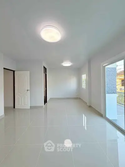 Spacious and bright empty room with glossy tiled flooring and modern lighting.
